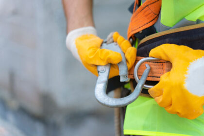 critical control management with a worker hooking up their safety harness