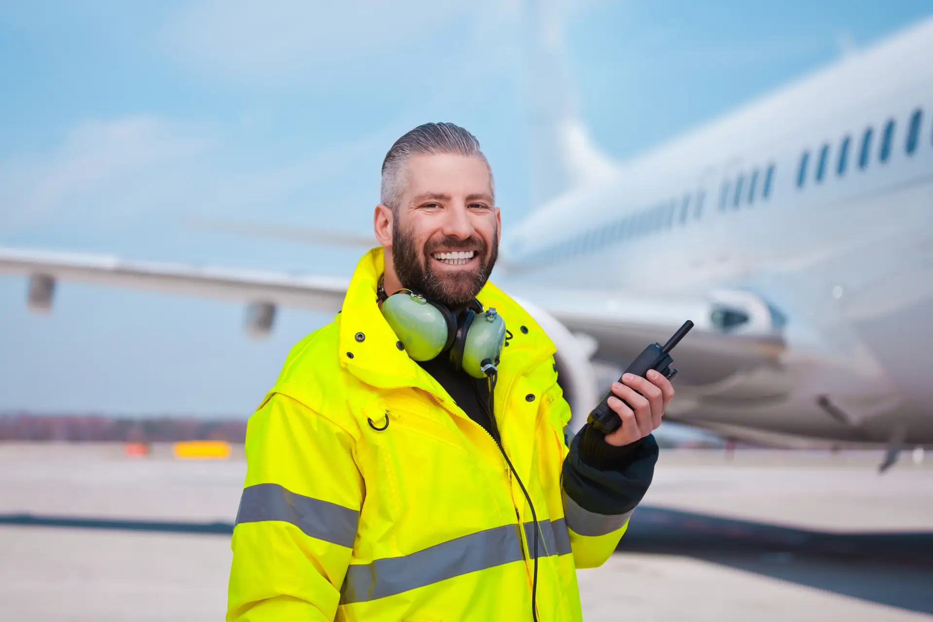 Happy ground crew aviation worker wearing high-vis
